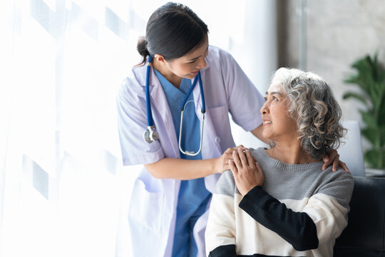 A caring nurse with a smiling senior woman at home